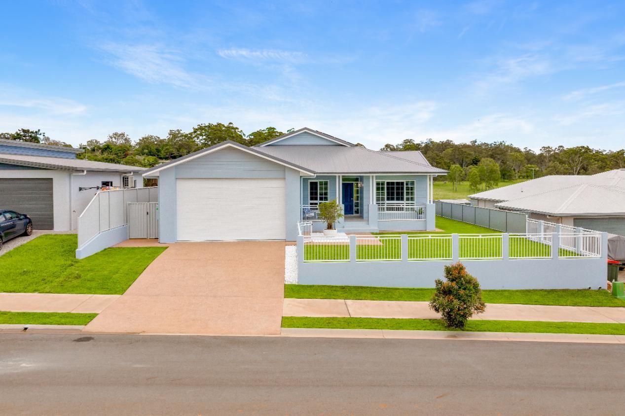 A White House With a White Fence and a Car Parked in Front of It — Ashlee Jones Homes in Gordonvale, QLD