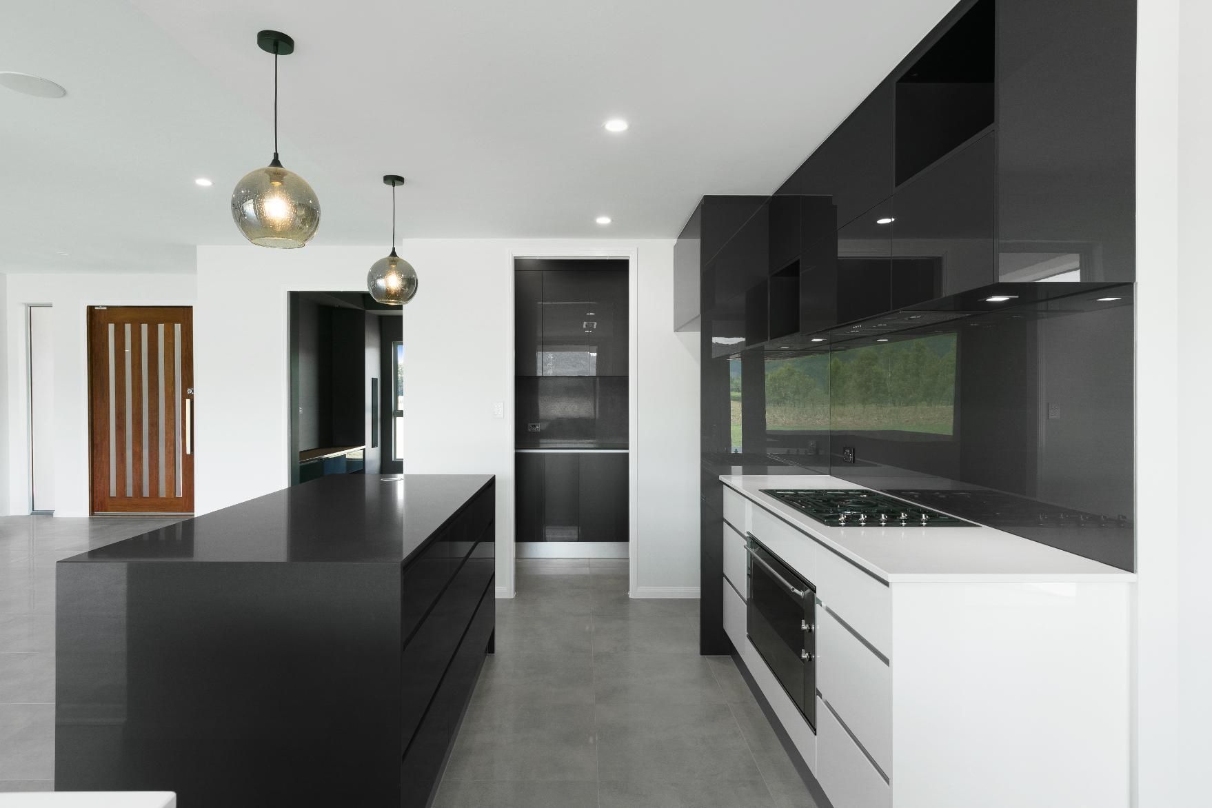 A Kitchen With Black Cabinets and White Counter Tops — Ashlee Jones Homes in Gordonvale, QLD