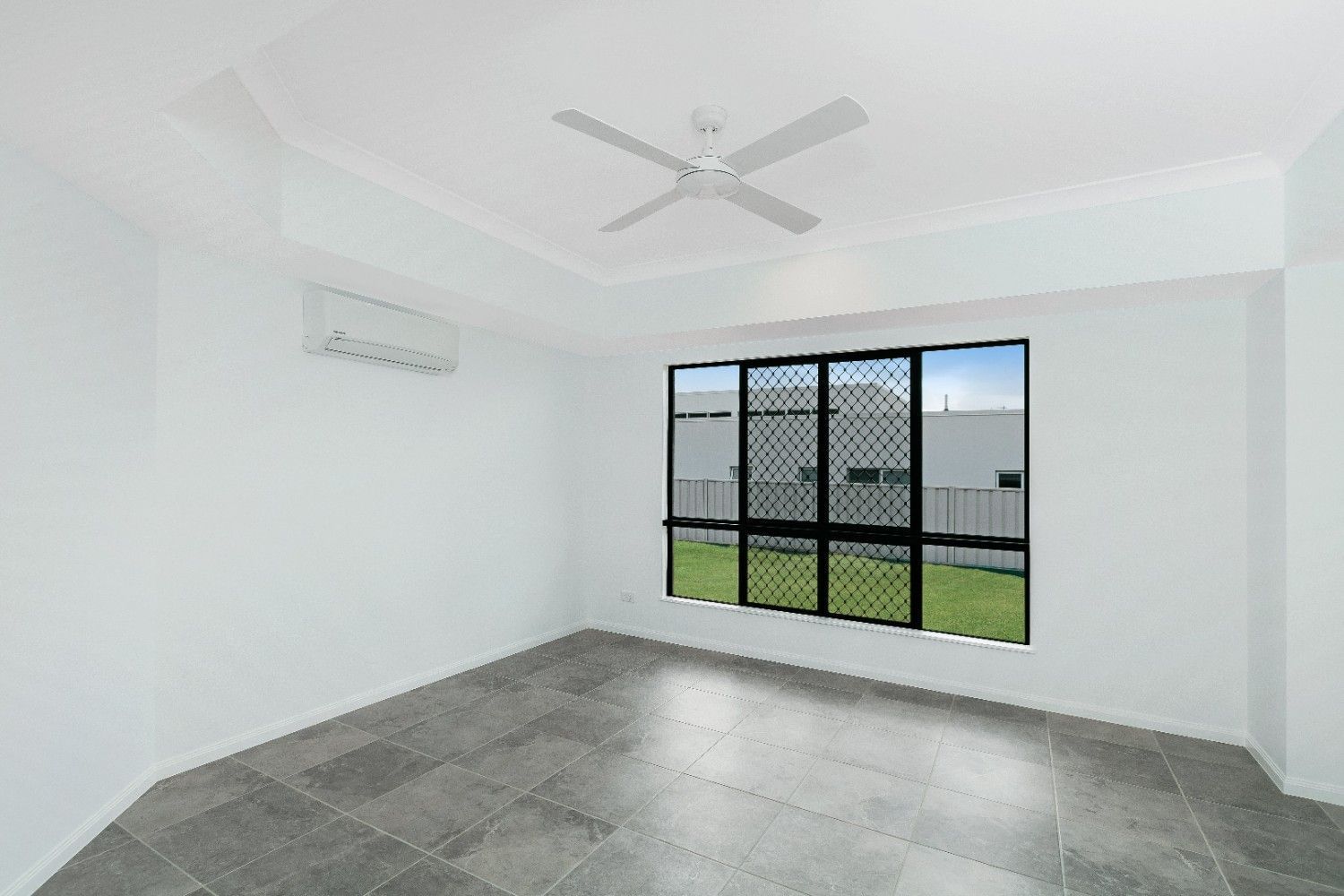 An Empty Room With a Ceiling Fan and a Window — Ashlee Jones Homes in Gordonvale, QLD