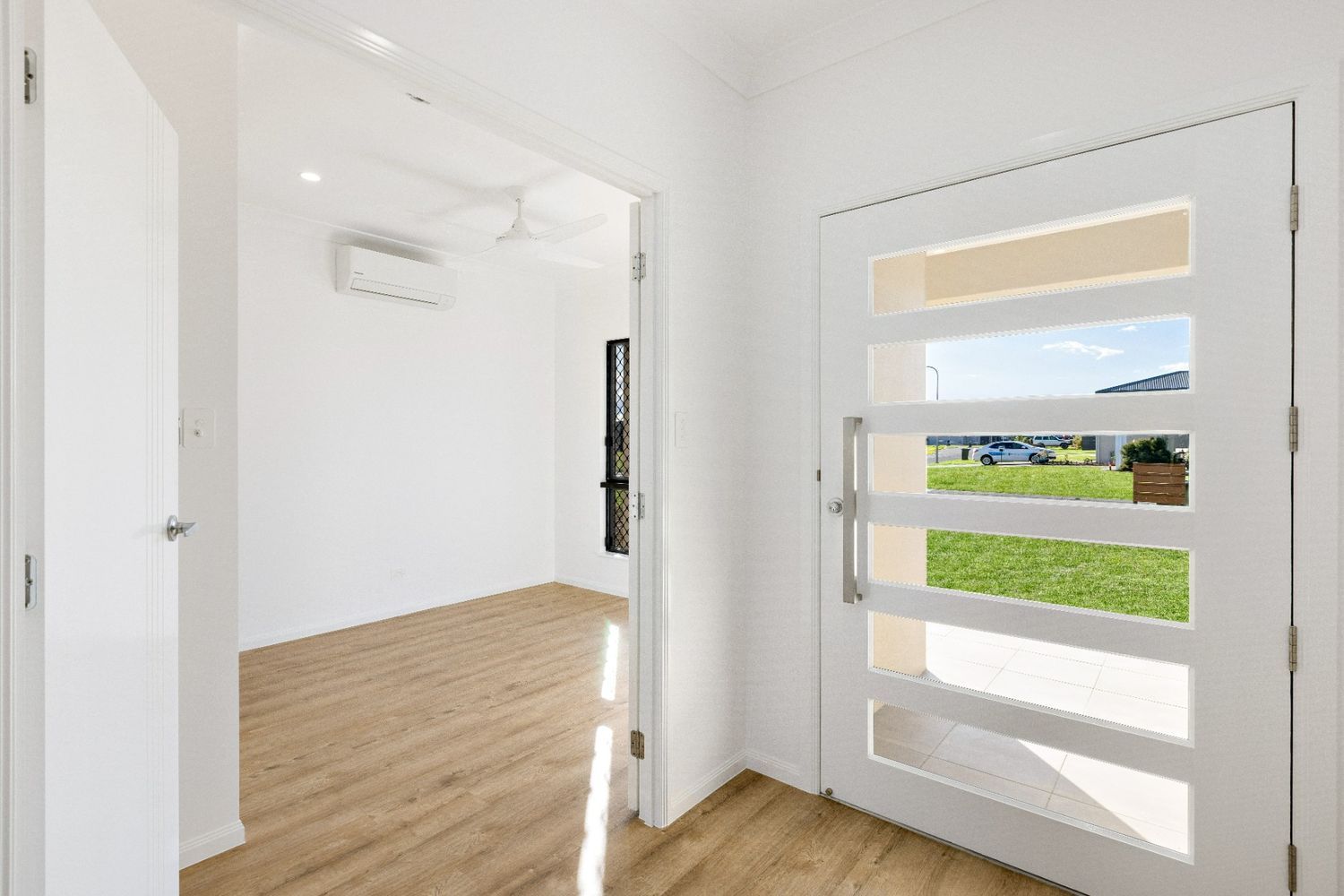 An Empty Room With a White Door and a Window — Ashlee Jones Homes in Gordonvale, QLD