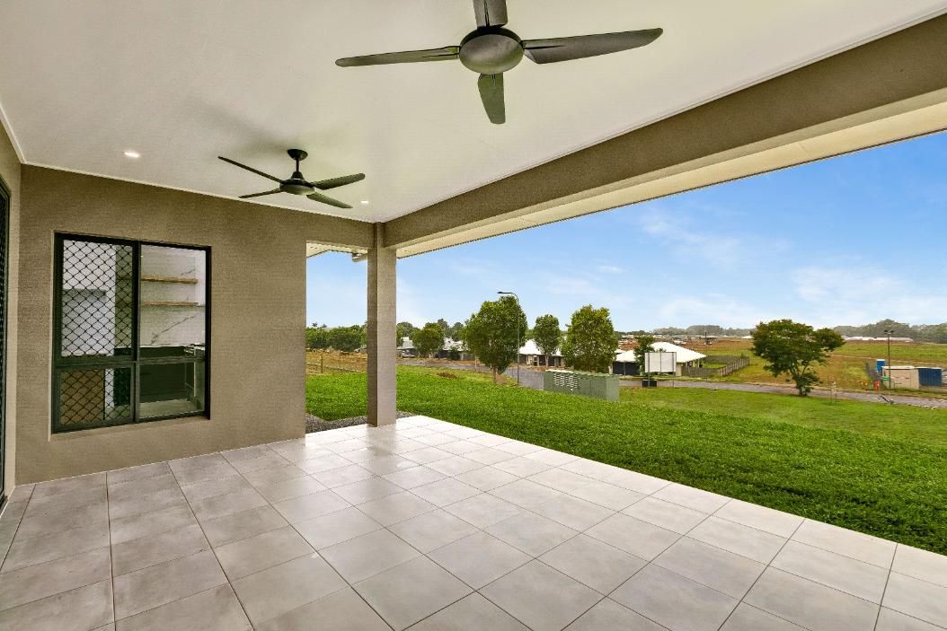 An Empty Patio With a Ceiling Fan and a View of a Grassy Field — Ashlee Jones Homes in Gordonvale, QLD
