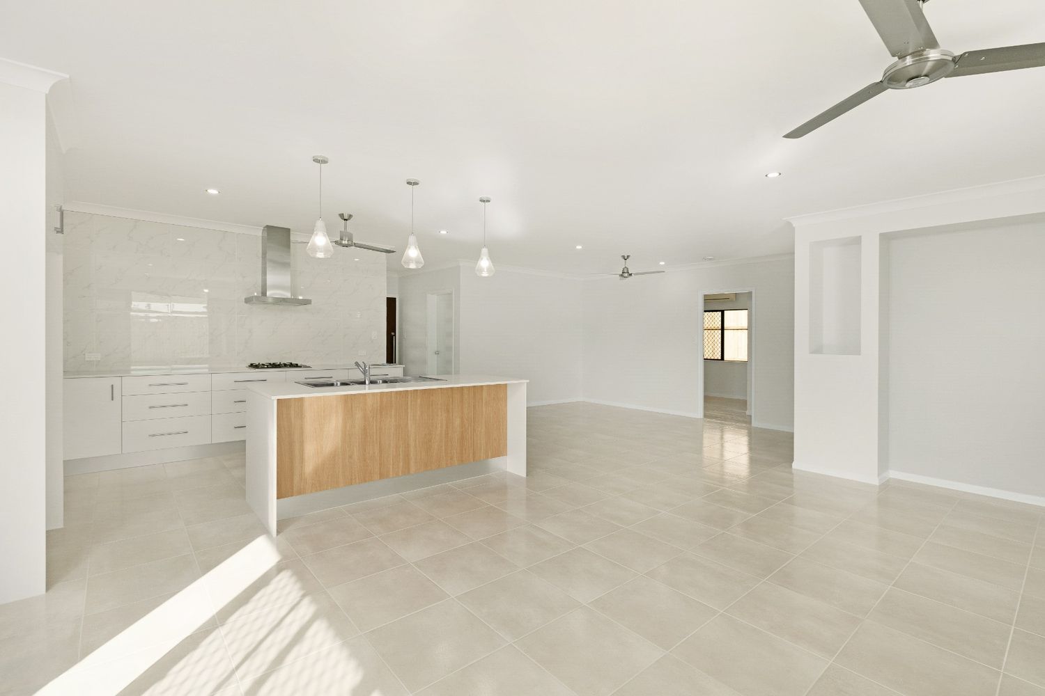 An Empty Room With a Kitchen and a Ceiling Fan — Ashlee Jones Homes in Gordonvale, QLD