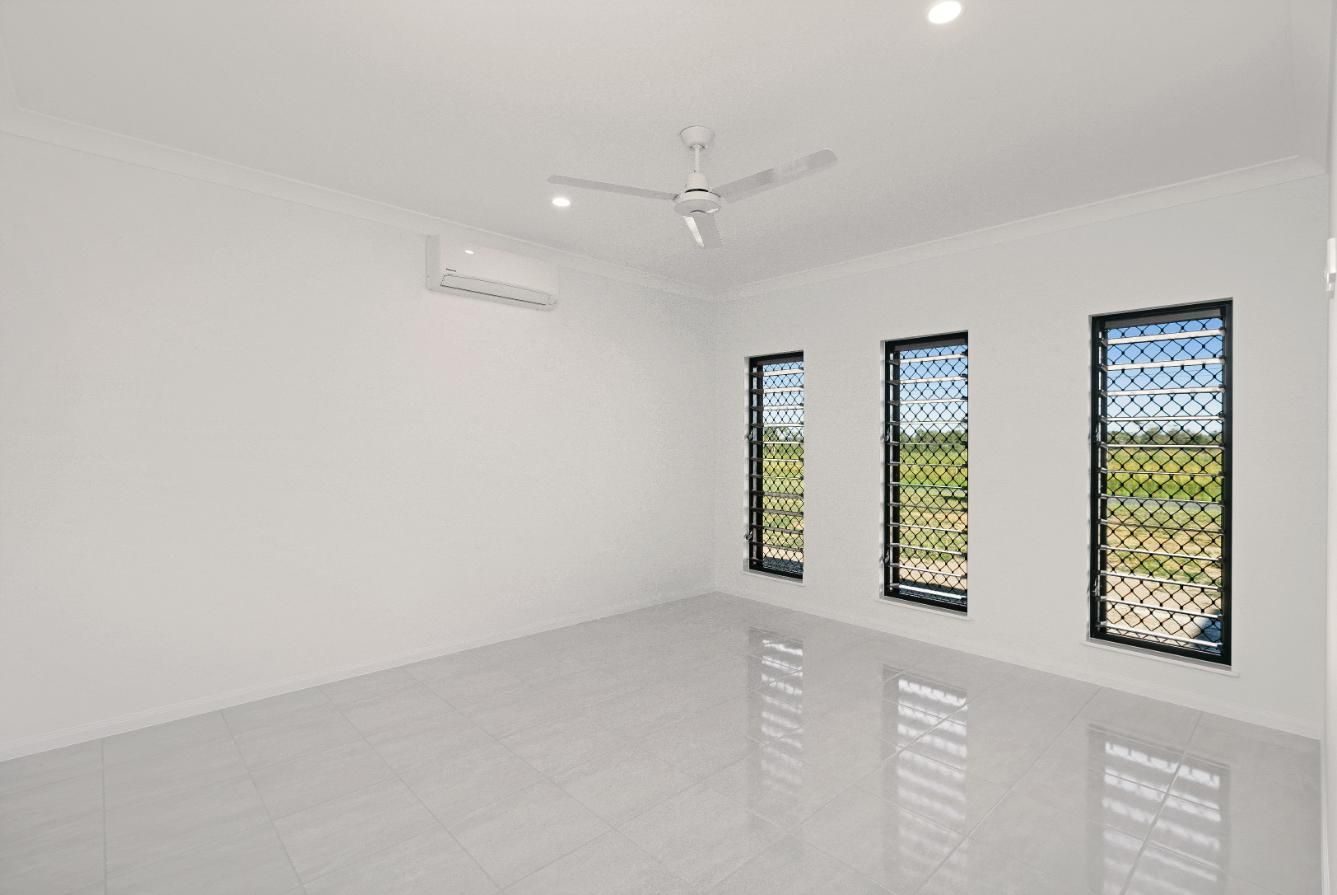 An Empty Room With Three Windows and a Ceiling Fan — Ashlee Jones Homes in Gordonvale, QLD