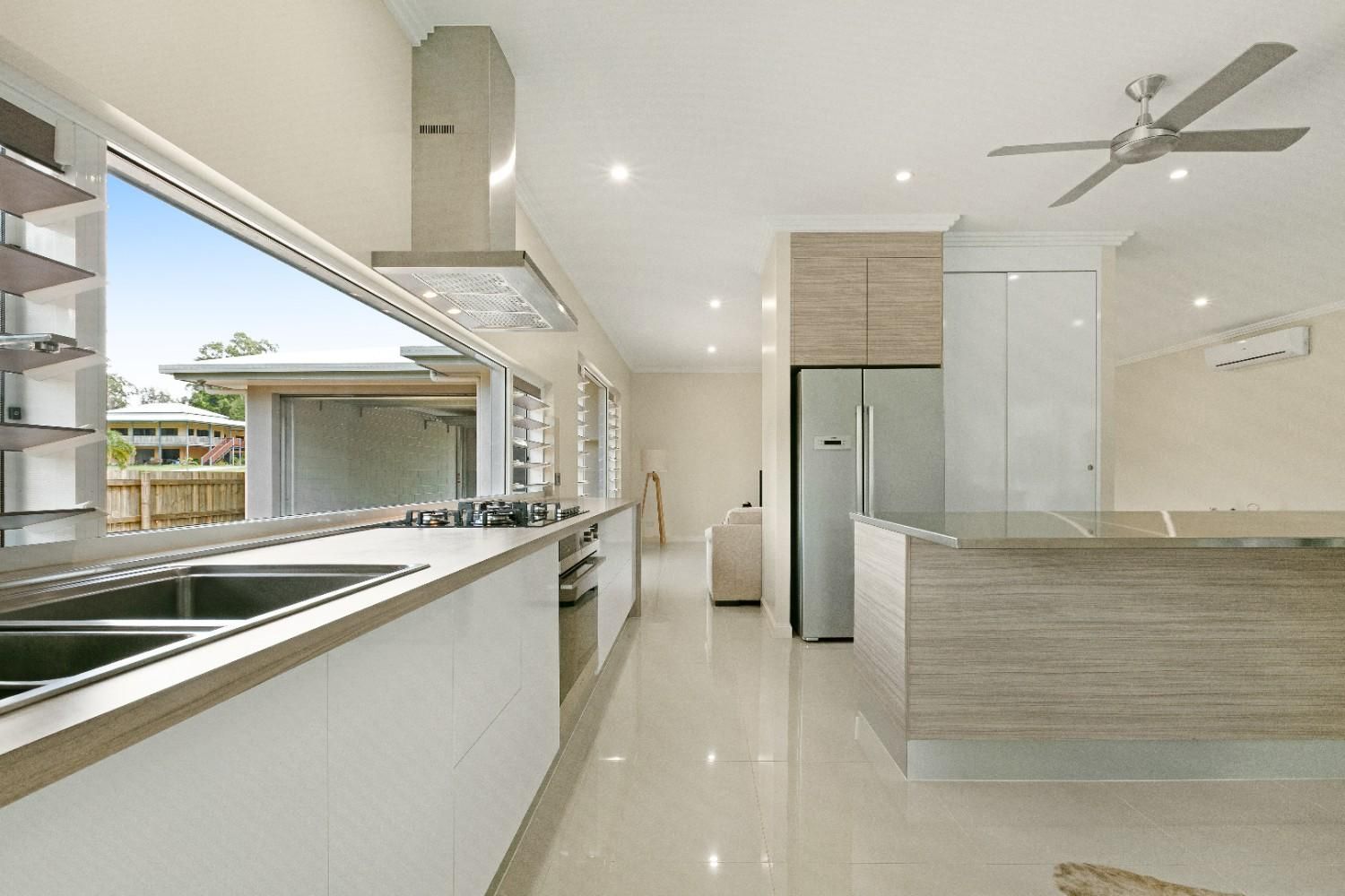 A Kitchen With Stainless Steel Appliances and a Ceiling Fan — Ashlee Jones Homes in Gordonvale, QLD