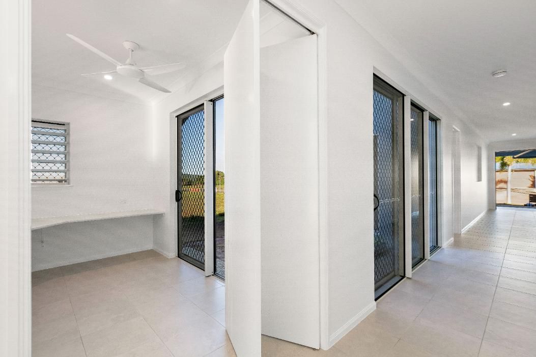 A Hallway in a House With Sliding Glass Doors and a Desk — Ashlee Jones Homes in Gordonvale, QLD