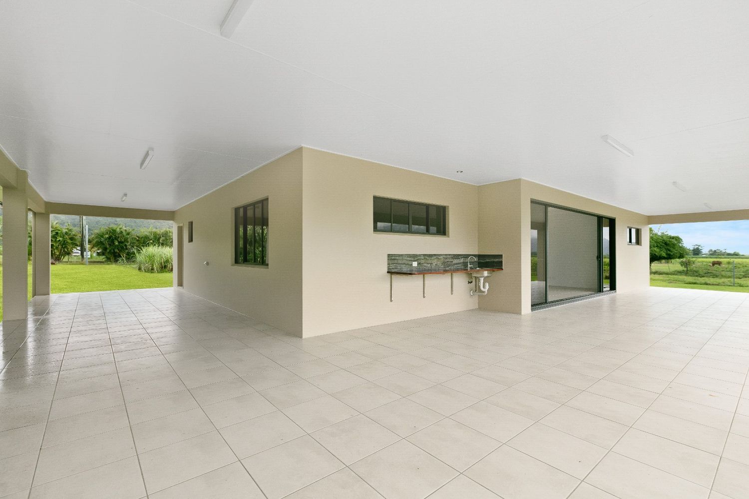 A Large Empty Garage With a Sink in the Middle of It — Ashlee Jones Homes in Gordonvale, QLD