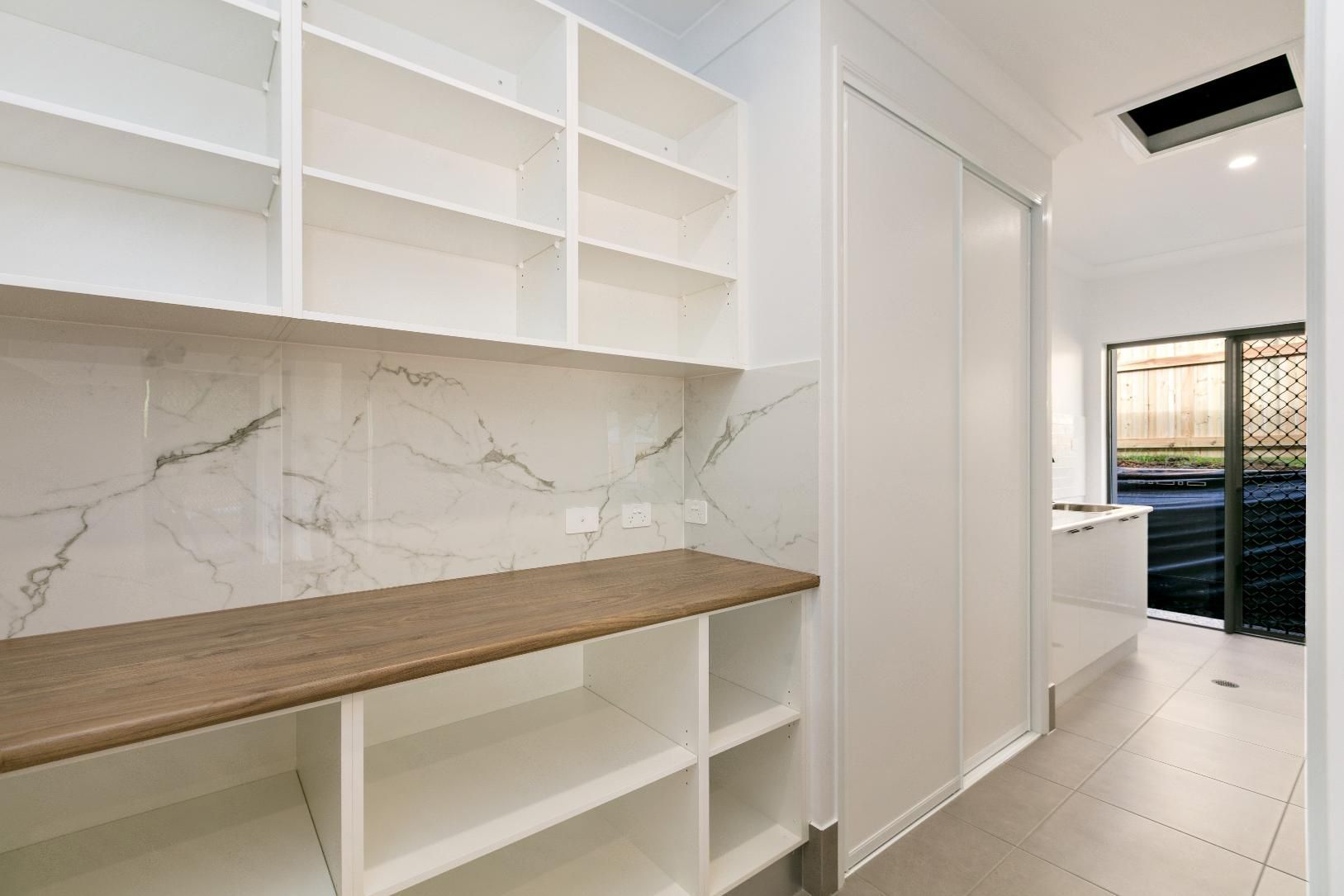 A Kitchen With a Wooden Counter Top and White Shelves — Ashlee Jones Homes in Gordonvale, QLD