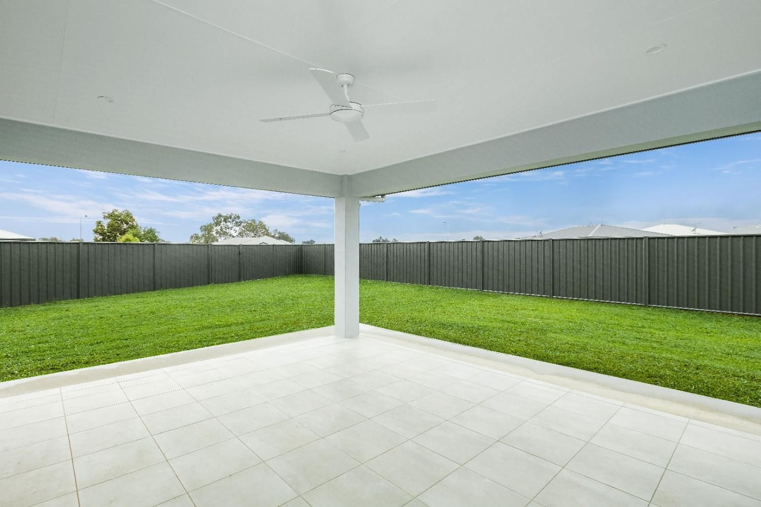 An Empty Patio With a Ceiling Fan and a Fence in the Background — Ashlee Jones Homes in Gordonvale, QLD