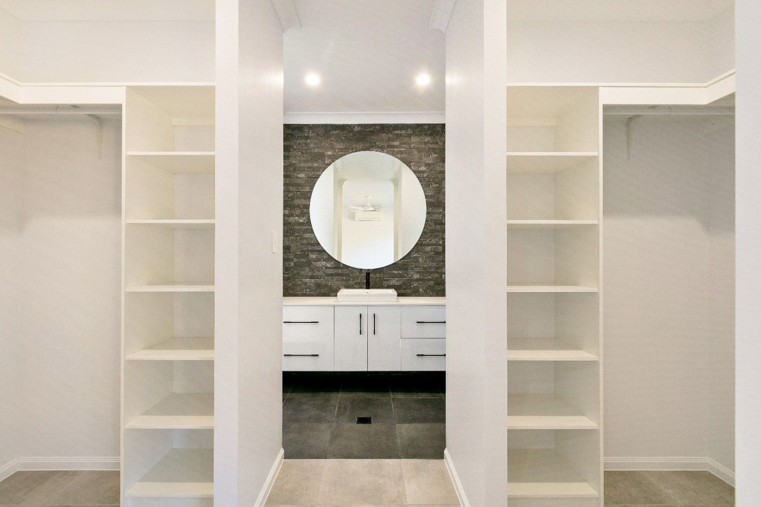 A Walk in Closet With Shelves and a Bathroom in the Background  — Ashlee Jones Homes in Gordonvale, QLD