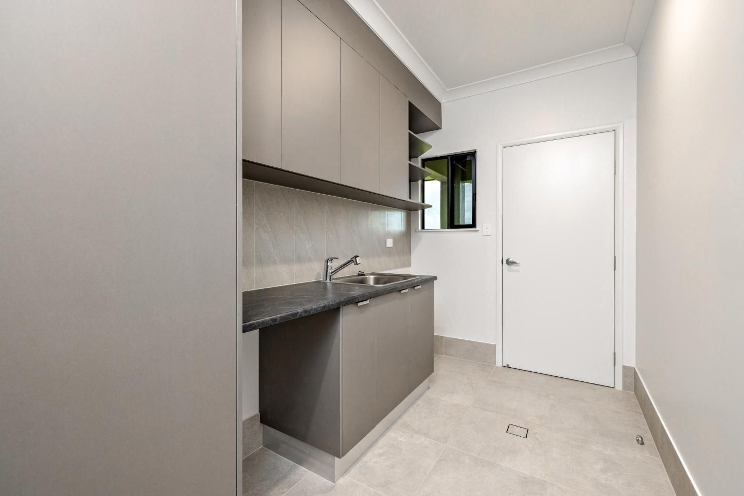 A Kitchen With a Sink, Cabinets, and a Door — Ashlee Jones Homes in Gordonvale, QLD