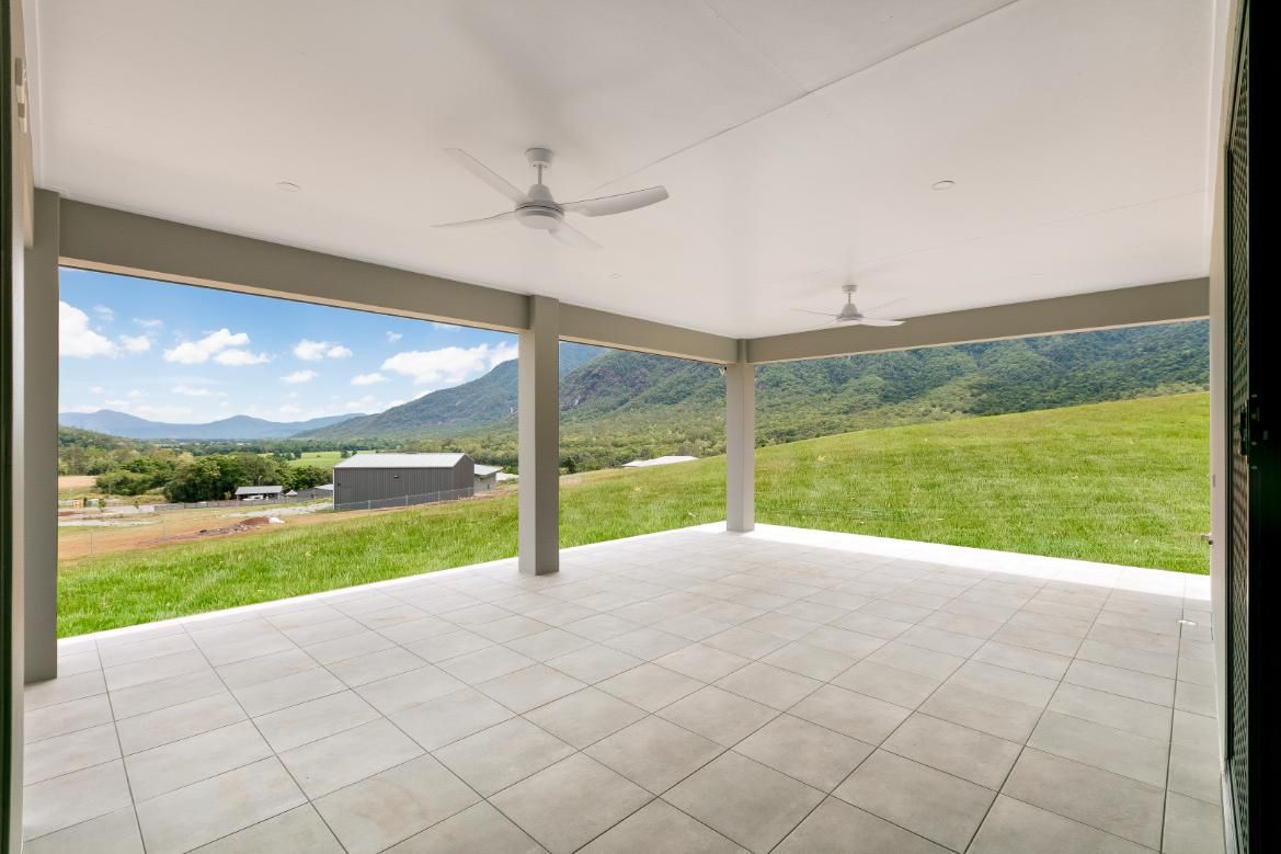 An Empty Patio With a Ceiling Fan and a View of a Grassy Field — Ashlee Jones Homes in Gordonvale, QLD