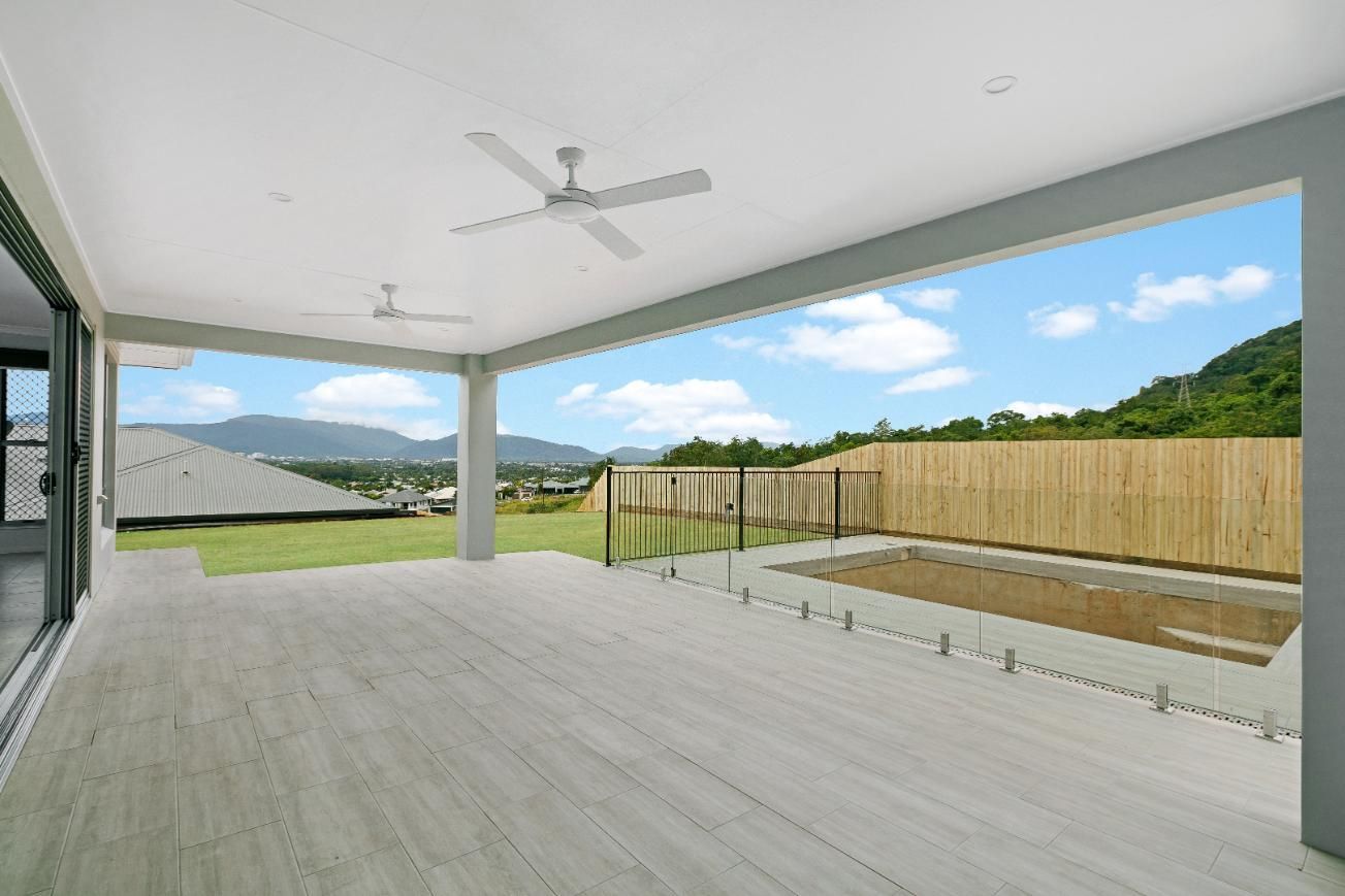 An Empty Patio With a Ceiling Fan and a View of a Swimming Pool — Ashlee Jones Homes in Gordonvale, QLD