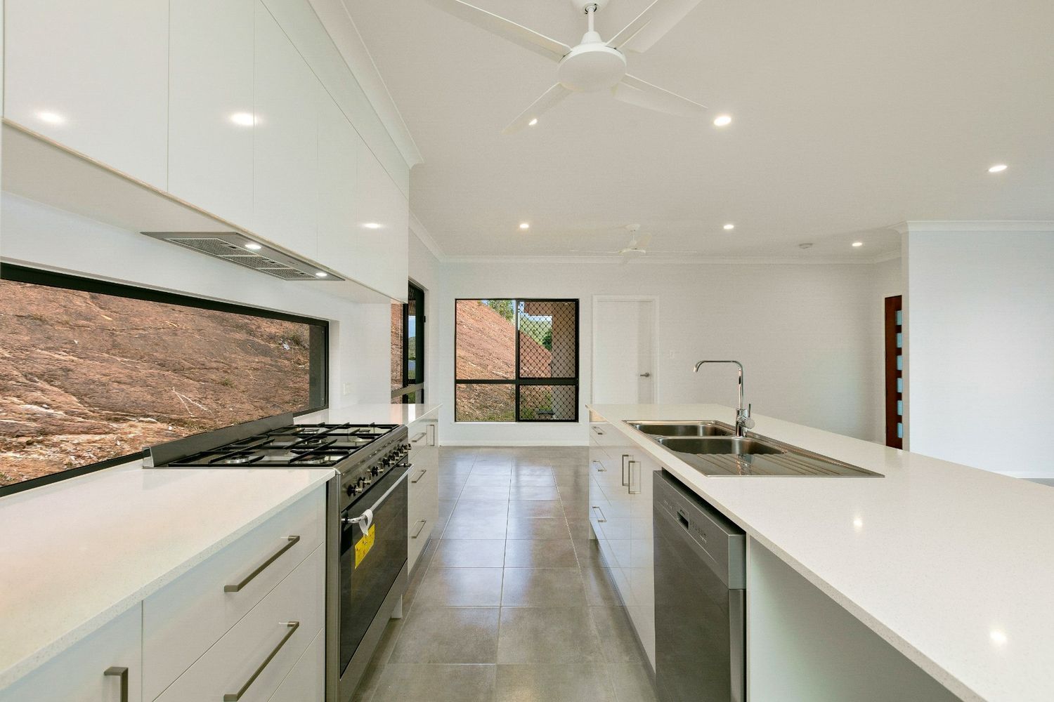 A Kitchen With White Cabinets and Stainless Steel Appliances — Ashlee Jones Homes in Gordonvale, QLD