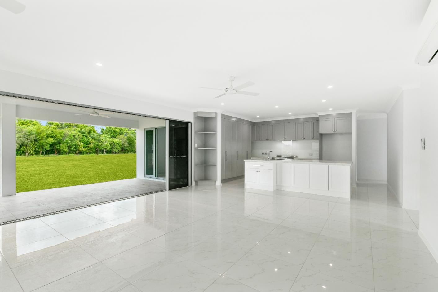 A Large Empty Room With a Kitchen and a Patio — Ashlee Jones Homes in Gordonvale, QLD