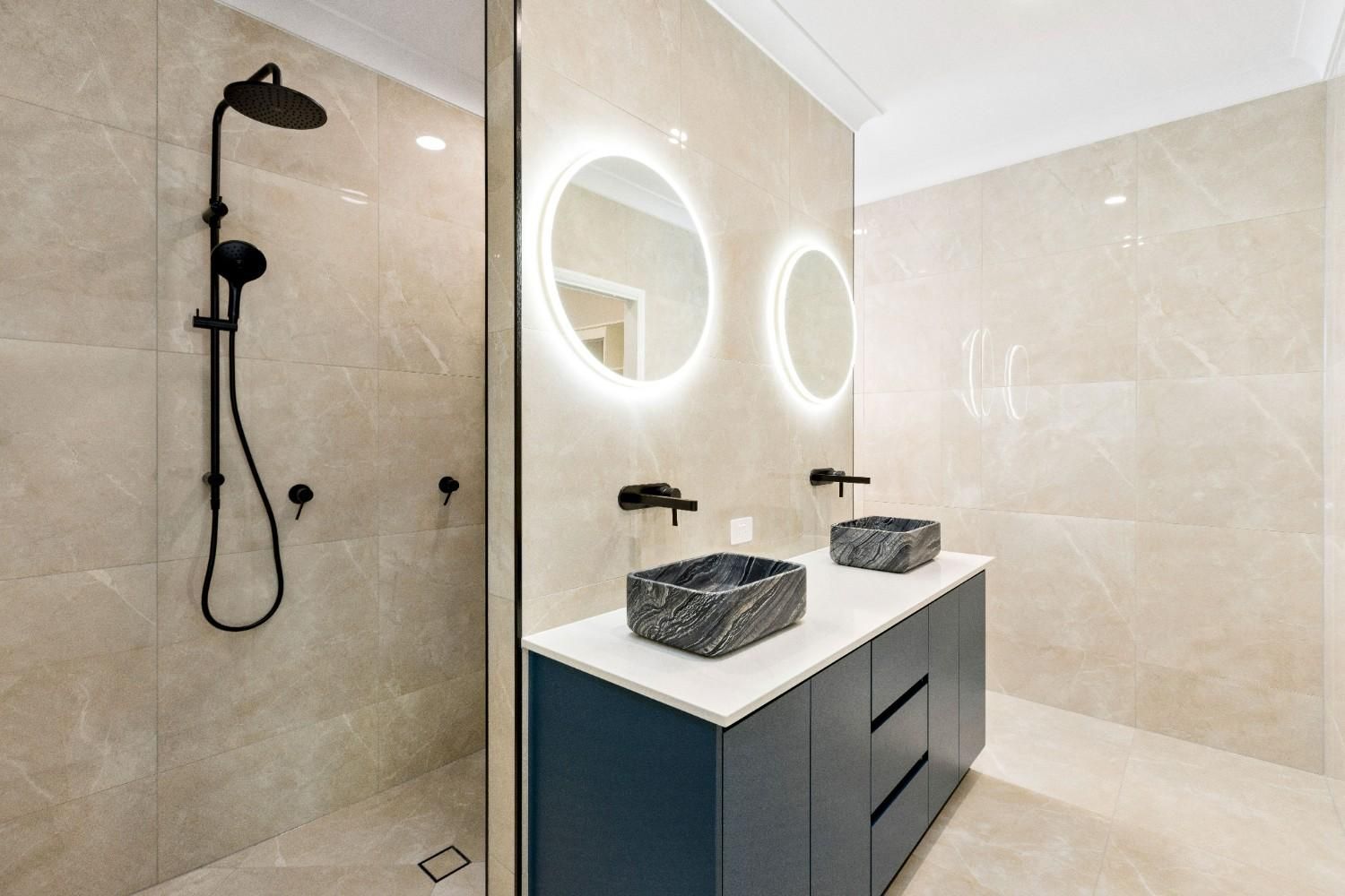 A Bathroom With Two Sinks, a Shower and a Mirror — Ashlee Jones Homes in Gordonvale, QLD