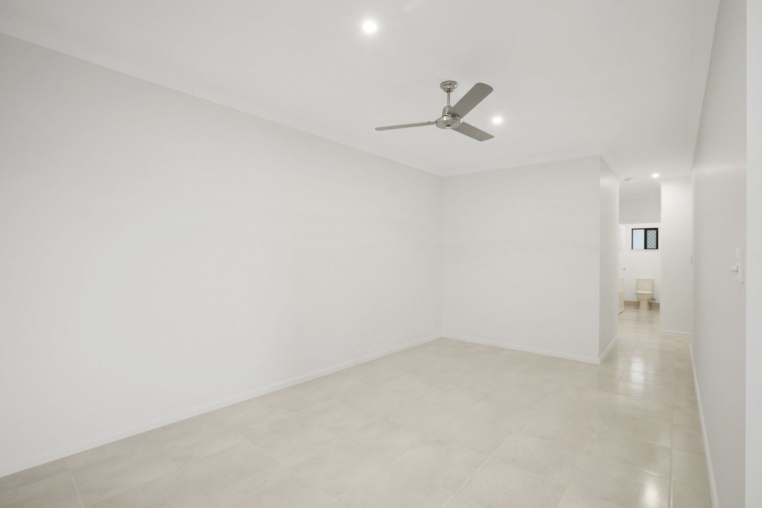 An Empty Room With a Ceiling Fan and White Walls — Ashlee Jones Homes in Gordonvale, QLD