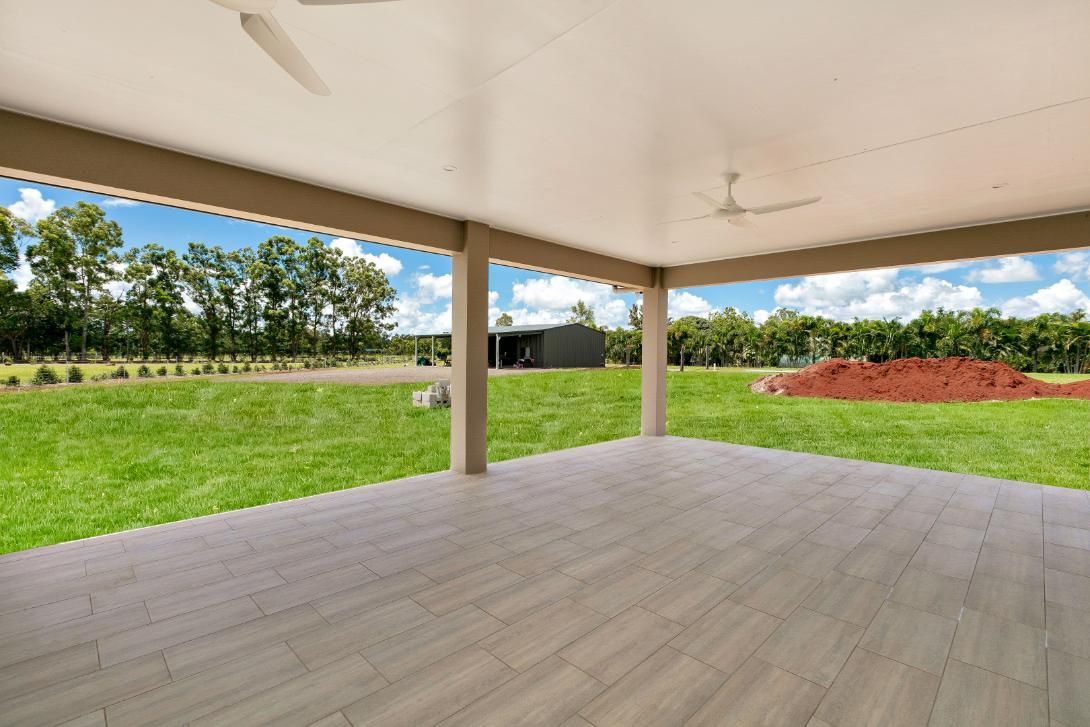 An Empty Patio With a Ceiling Fan and a View of a Grassy Field — Ashlee Jones Homes in Gordonvale, QLD