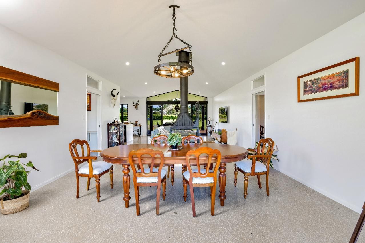 A Dining Room With a Table and Chairs and a Fireplace — Ashlee Jones Homes in Gordonvale, QLD
