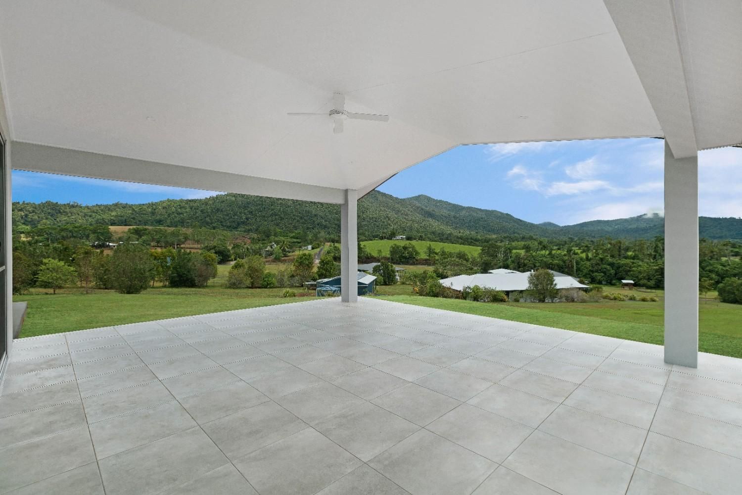 An Empty Patio With a View of a Field and Mountains — Ashlee Jones Homes in Gordonvale, QLD