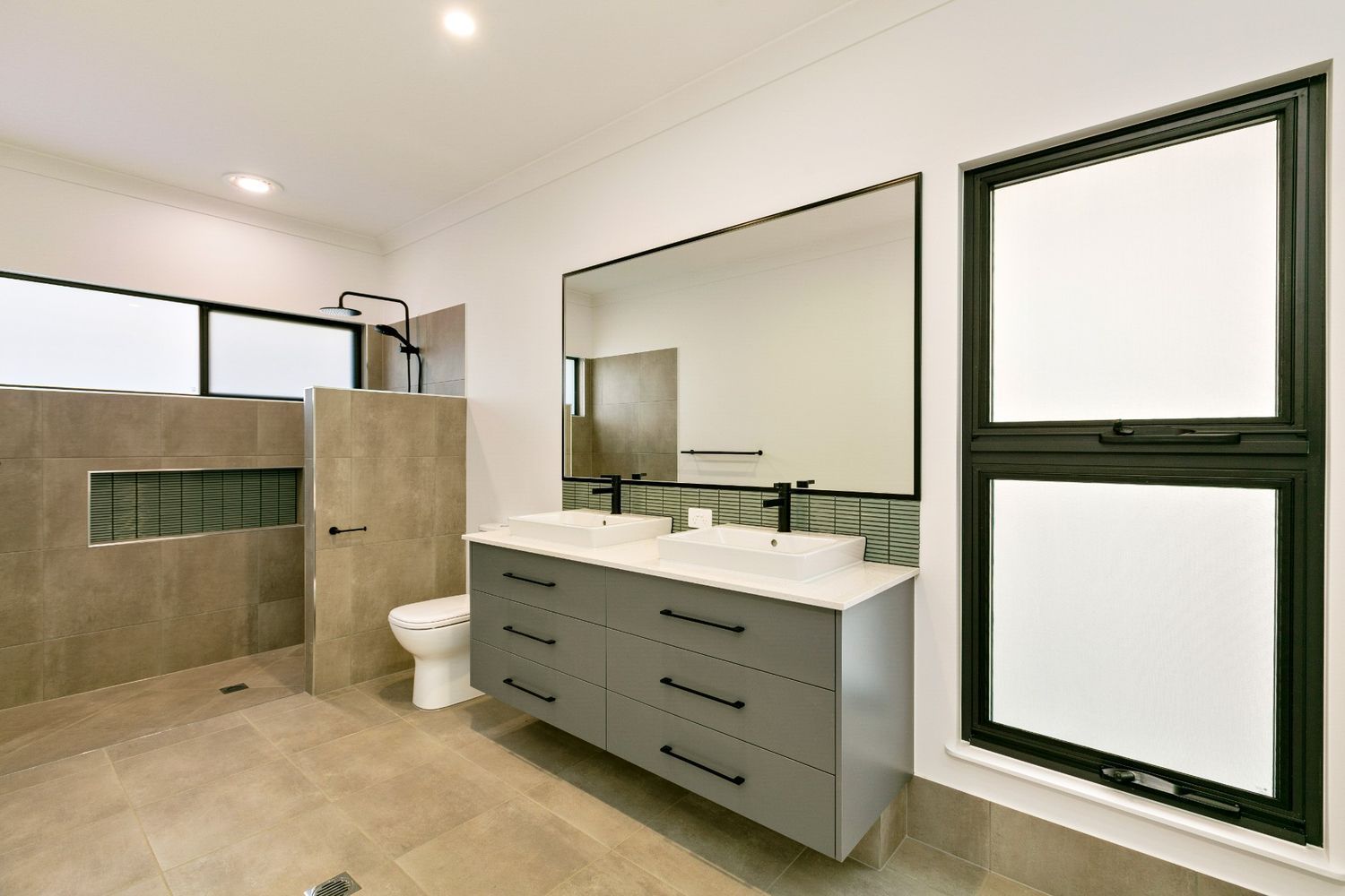A Bathroom With Two Sinks, a Toilet, and a Large Mirror — Ashlee Jones Homes in Gordonvale, QLD