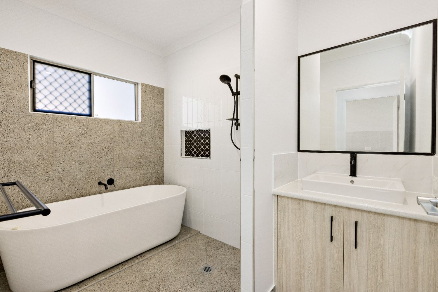 A Bathroom With a Bathtub, Sink, Mirror and Shower — Ashlee Jones Homes in Gordonvale, QLD