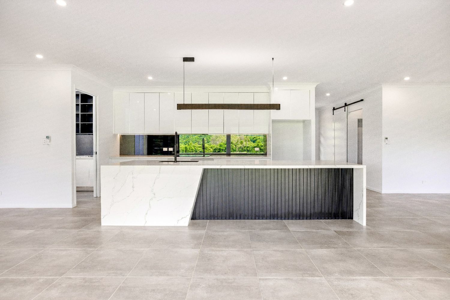 A Kitchen With a Large Island in the Middle of the Room — Ashlee Jones Homes in Gordonvale, QLD