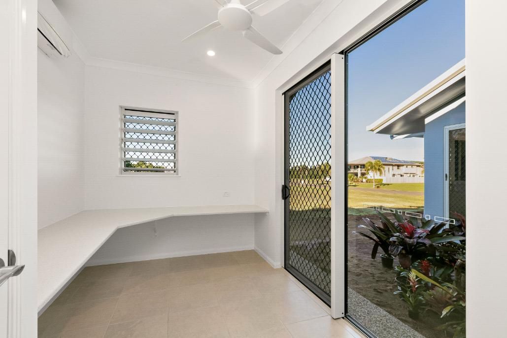 A Room With a Sliding Glass Door and a Ceiling Fan — Ashlee Jones Homes in Gordonvale, QLD