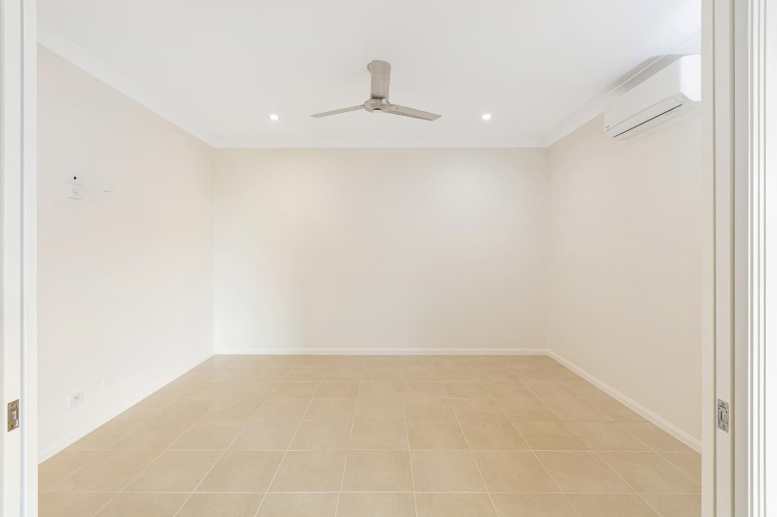 An Empty Room With a Ceiling Fan and Air Conditioner — Ashlee Jones Homes in Gordonvale, QLD