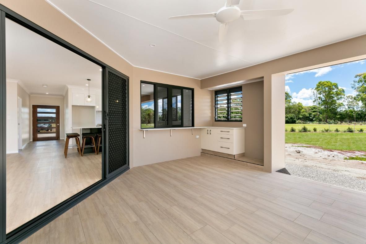 An Empty Room With Sliding Glass Doors and a Ceiling Fan — Ashlee Jones Homes in Gordonvale, QLD