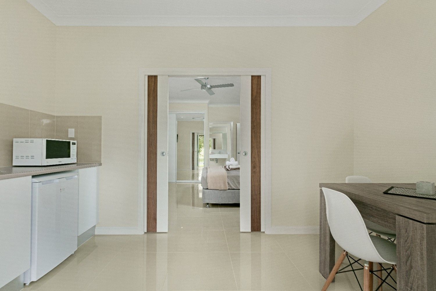 A Kitchen With a Table and Chairs and a Microwave — Ashlee Jones Homes in Gordonvale, QLD