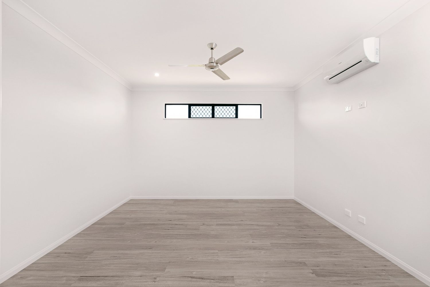 An Empty Room With a Ceiling Fan and a Window — Ashlee Jones Homes in Gordonvale, QLD