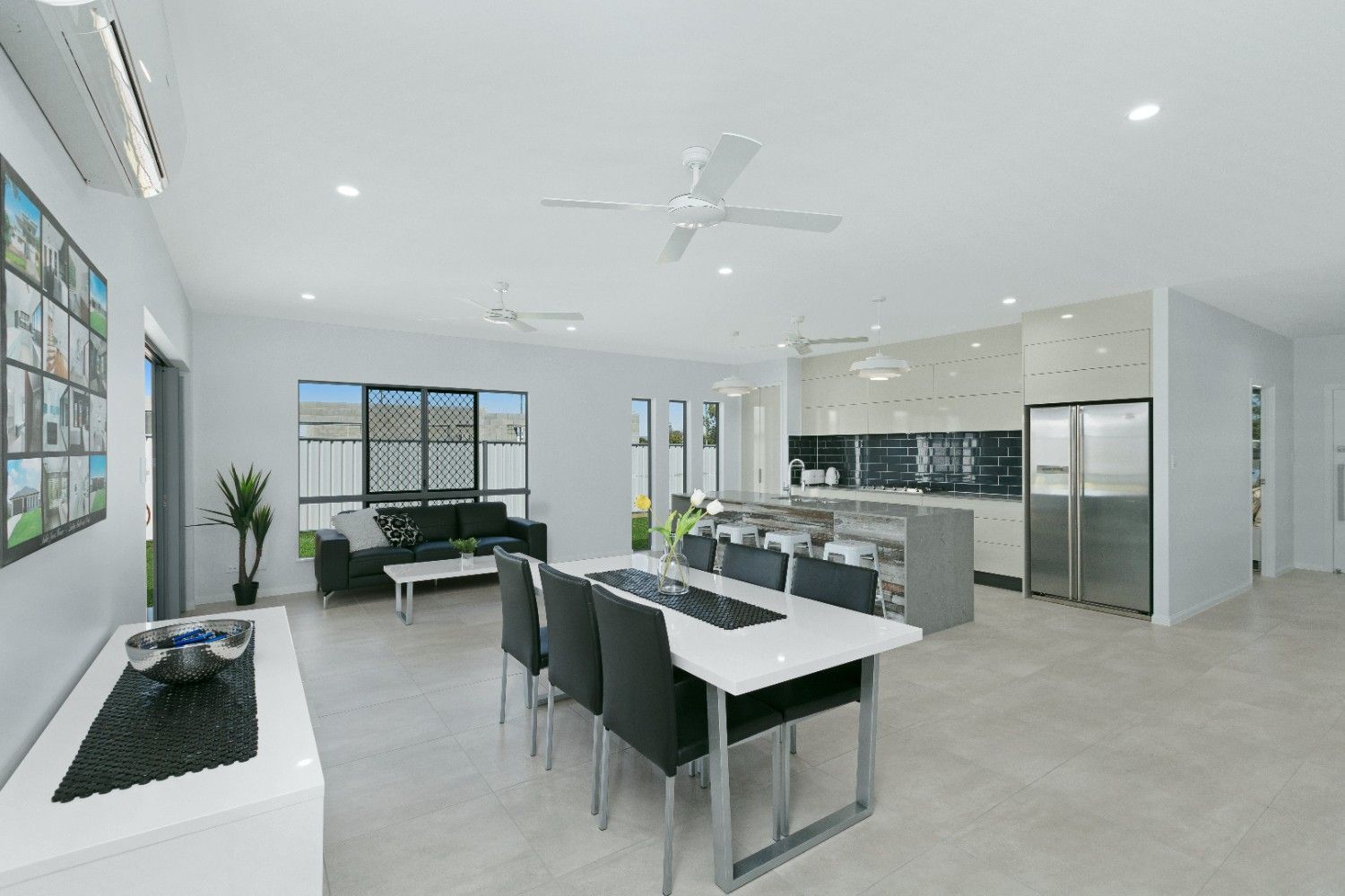 A Living Room With a Dining Table and Chairs and a Ceiling Fan — Ashlee Jones Homes in Gordonvale, QLD
