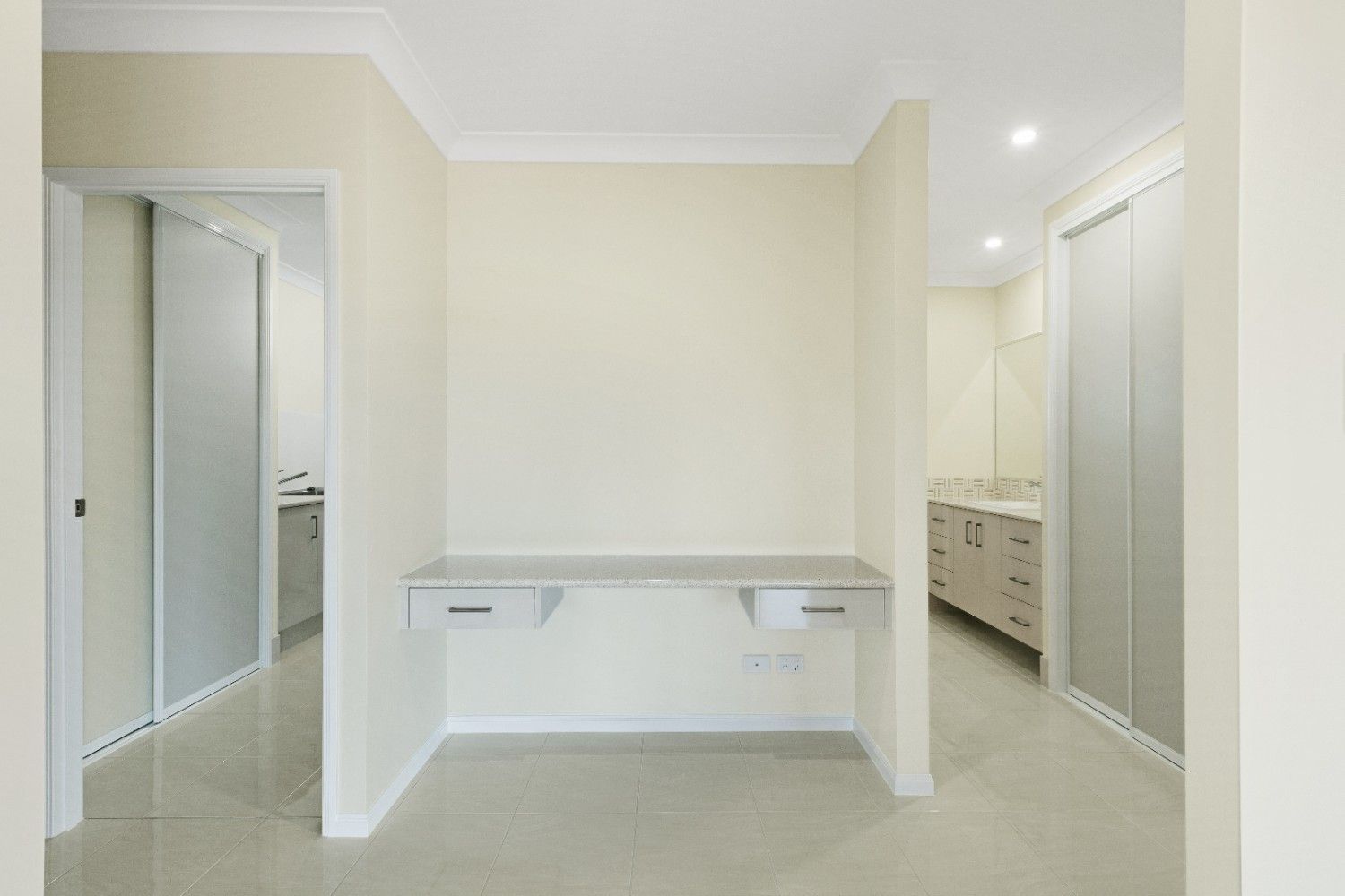 An Empty Room With a Desk and a Bathroom in the Background — Ashlee Jones Homes in Gordonvale, QLD