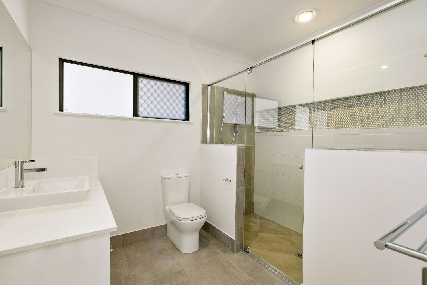 A Bathroom With a Toilet, Sink and Shower — Ashlee Jones Homes in Gordonvale, QLD