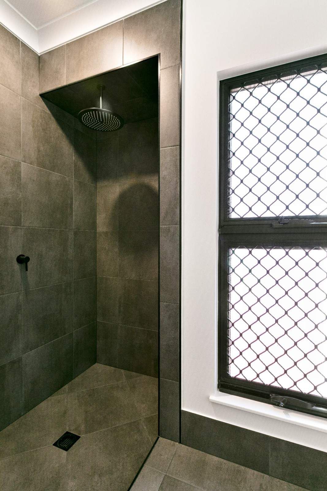 A Bathroom With a Walk in Shower and Two Windows — Ashlee Jones Homes in Gordonvale, QLD