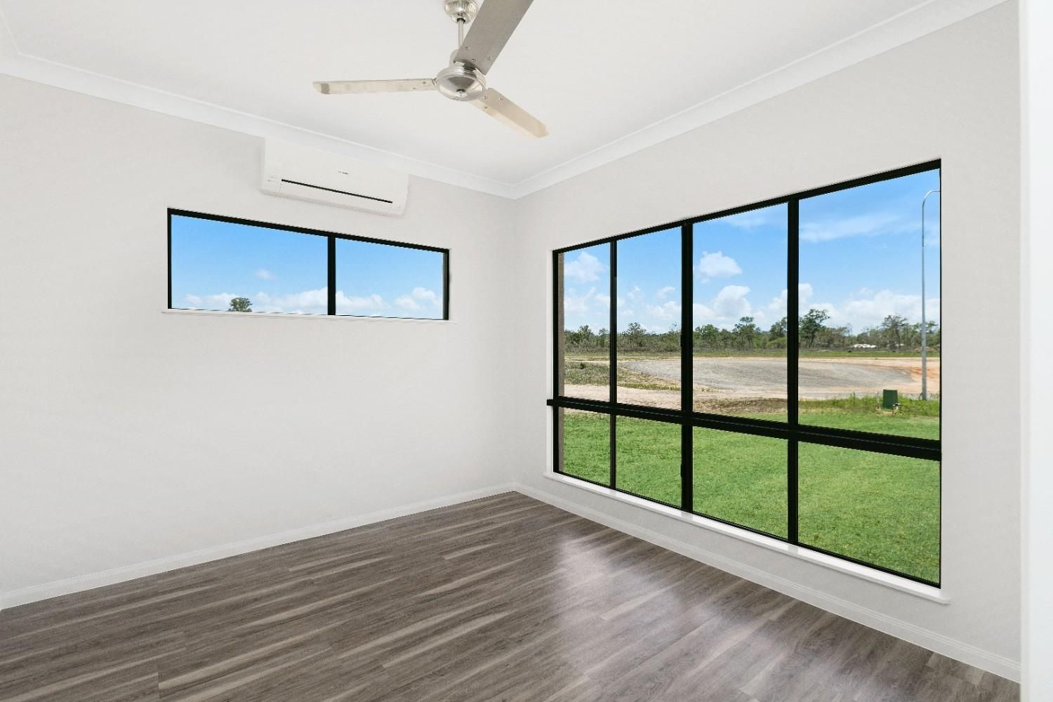 An Empty Room With a Lot of Windows and a Ceiling Fan — Ashlee Jones Homes in Gordonvale, QLD