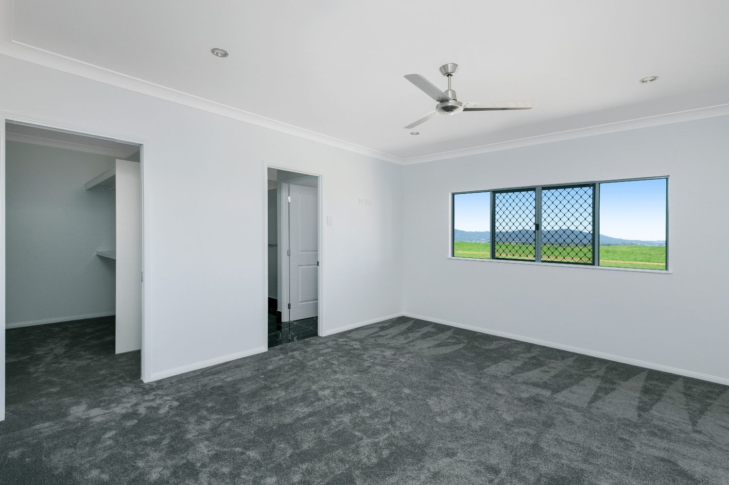 An Empty Room With a Ceiling Fan and a Window — Ashlee Jones Homes in Gordonvale, QLD