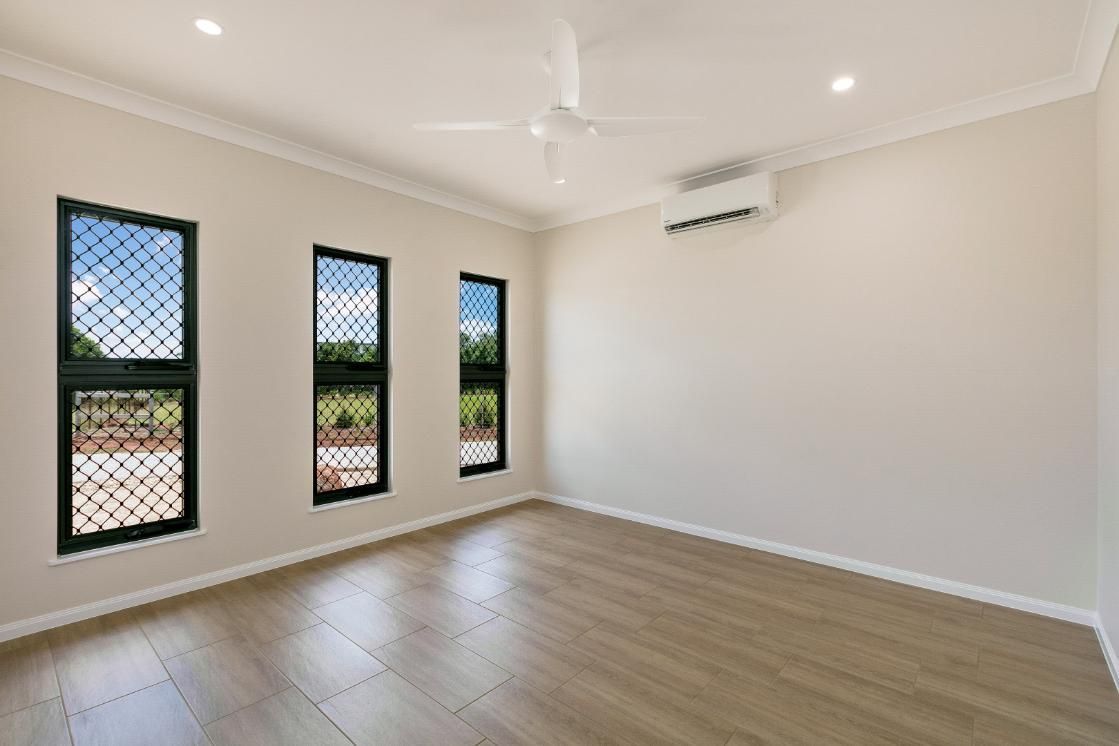 An Empty Room With Three Windows and a Ceiling Fan — Ashlee Jones Homes in Gordonvale, QLD