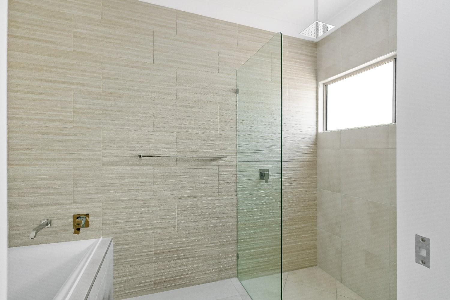 A Bathroom With a Walk in Shower and a Sink — Ashlee Jones Homes in Gordonvale, QLD