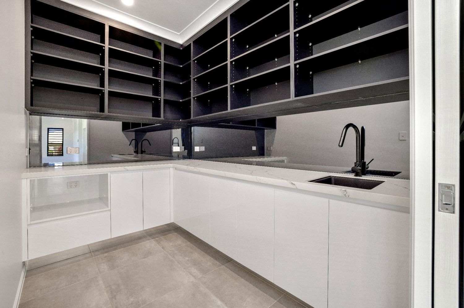 A Kitchen With White Cabinets and Black Shelves and a Sink — Ashlee Jones Homes in Gordonvale, QLD