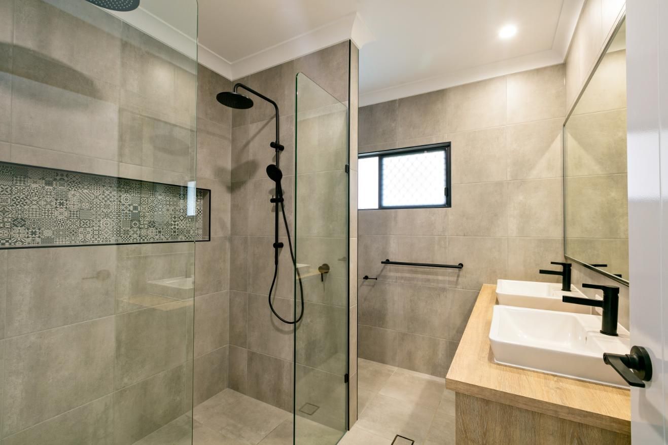 A Bathroom With a Walk in Shower and Two Sinks — Ashlee Jones Homes in Gordonvale, QLD