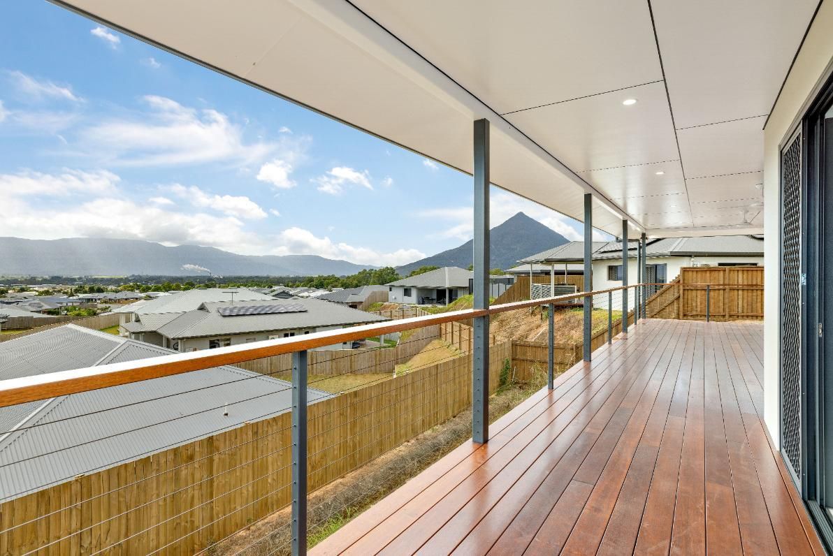 A Large Wooden Deck With a View of a Mountain and Houses — Ashlee Jones Homes in Gordonvale, QLD