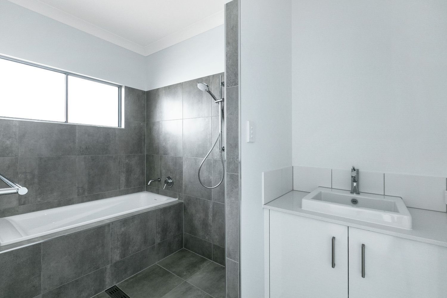 A Bathroom With a Bathtub, Sink, and Shower — Ashlee Jones Homes in Gordonvale, QLD