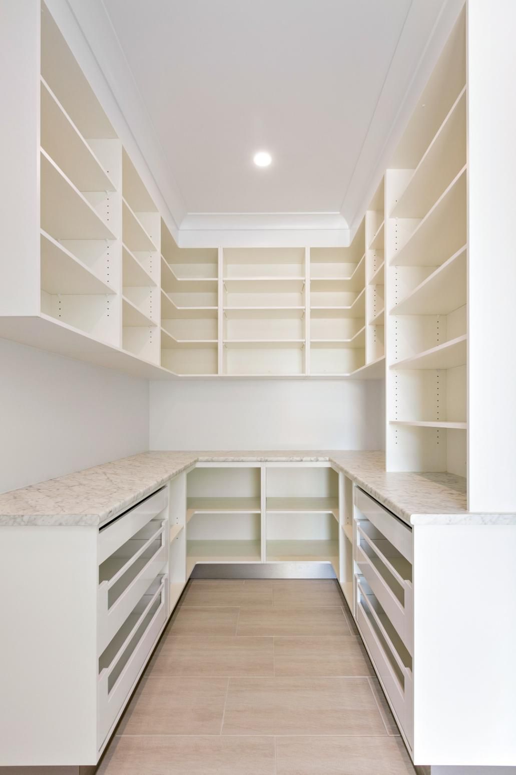 An Empty Pantry With Lots of Shelves and Drawers — Ashlee Jones Homes in Gordonvale, QLD
