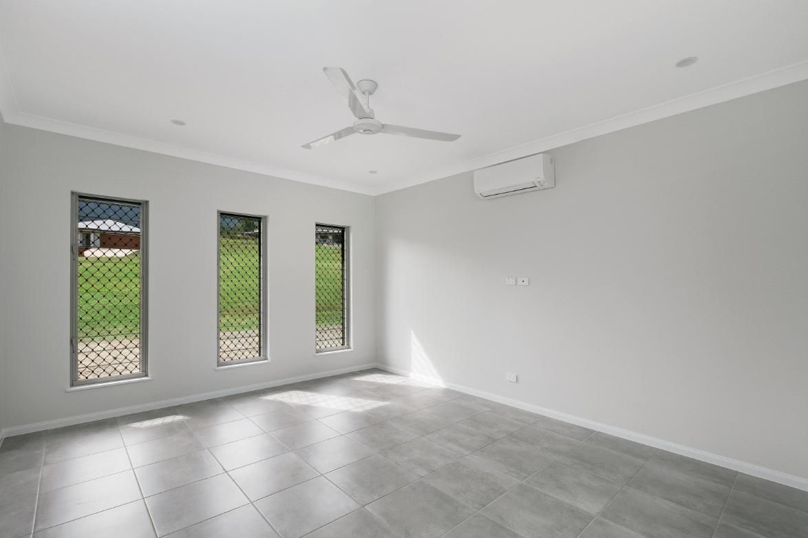 An Empty Room With Three Windows and a Ceiling Fan — Ashlee Jones Homes in Gordonvale, QLD