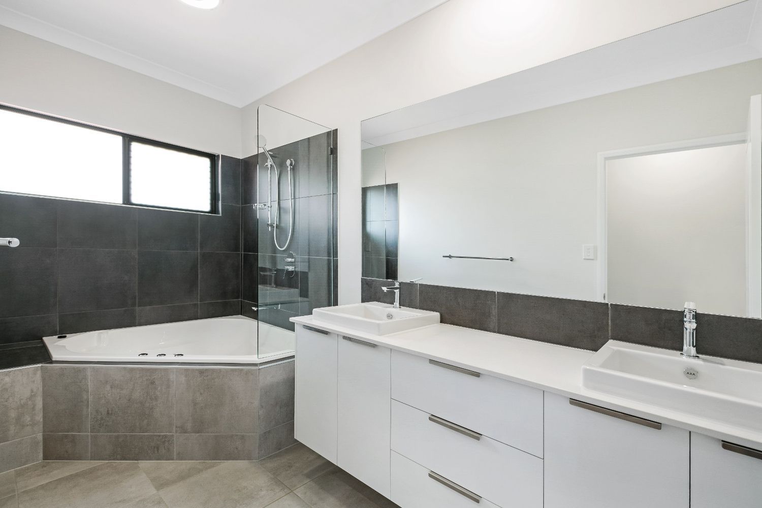 A Bathroom With a Tub, Sink and Mirror — Ashlee Jones Homes in Gordonvale, QLD