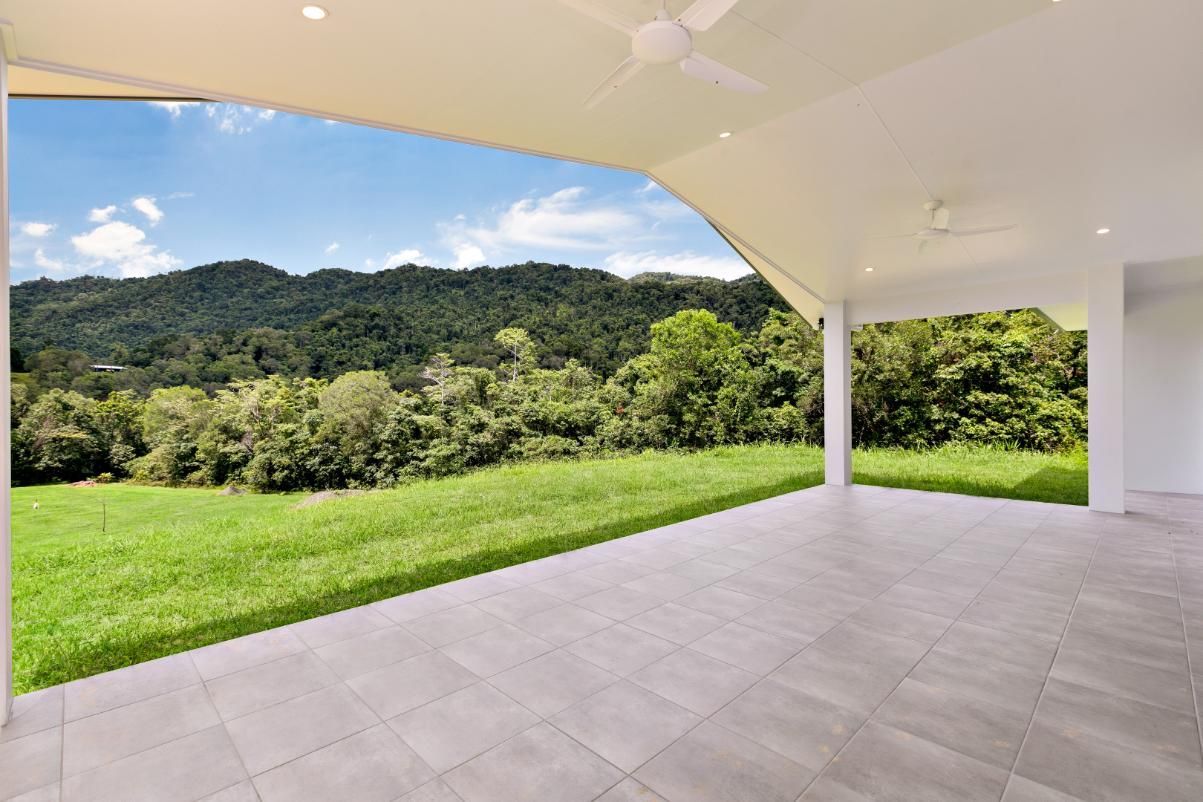 An Empty Patio With a View of a Grassy Field and Mountains — Ashlee Jones Homes in Gordonvale, QLD