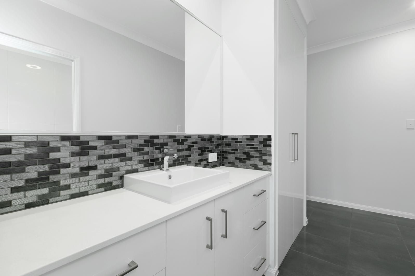 A Bathroom With a Sink and a Mirror — Ashlee Jones Homes in Gordonvale, QLD