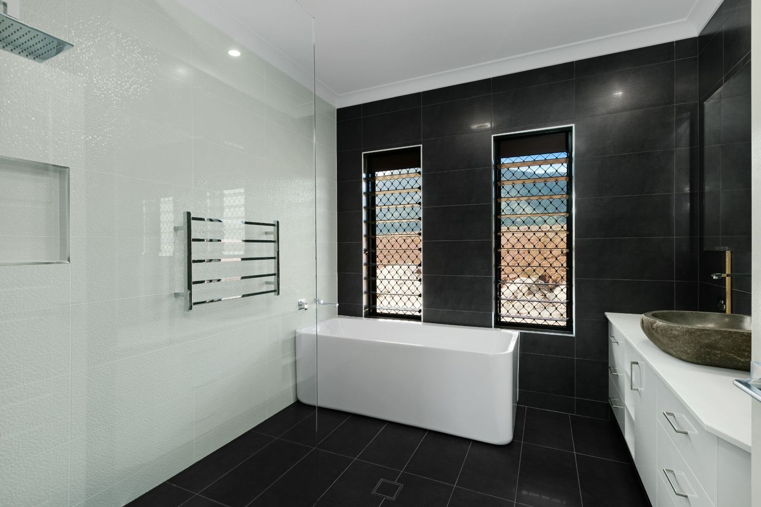 A Bathroom With a Bathtub, Sink, and Shower — Ashlee Jones Homes in Gordonvale, QLD
