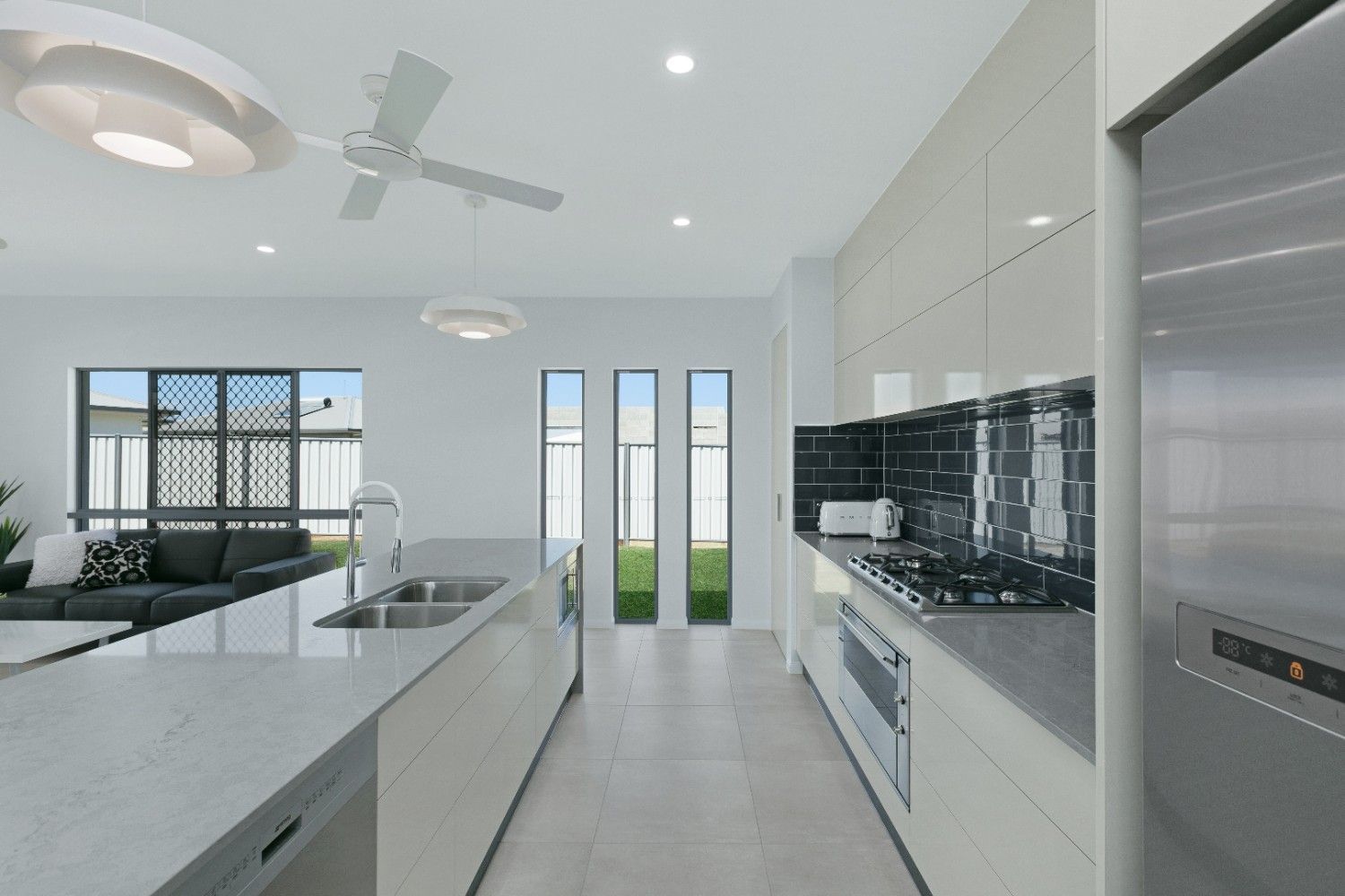 A Kitchen With Stainless Steel Appliances and a Ceiling Fan — Ashlee Jones Homes in Gordonvale, QLD
